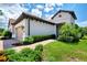 Beautiful home exterior with a terra cotta roof, tan garage door, and meticulously maintained landscaping at 26950 Pavin Dr, Englewood, FL 34223