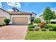 Charming home with a brick driveway, beige garage door, terra cotta roof, and lush landscaping at 26950 Pavin Dr, Englewood, FL 34223