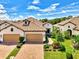 Stunning exterior elevation with lush landscaping, brick driveway, a barrel tile roof, and attached two-car garage at 26950 Pavin Dr, Englewood, FL 34223