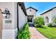 Charming front entrance with manicured landscaping, a brick walkway, and visible house number at 26950 Pavin Dr, Englewood, FL 34223