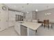 Modern kitchen with stainless steel appliances, pendant lighting over a large island with bar seating at 26950 Pavin Dr, Englewood, FL 34223