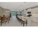 Open-concept kitchen featuring white cabinetry, an island with bar seating, and stainless steel appliances at 26950 Pavin Dr, Englewood, FL 34223