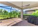 Covered patio with screened enclosure, brick pavers, and lush landscaping at 26950 Pavin Dr, Englewood, FL 34223