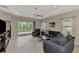 Bright living room with ceiling fan, tile floors, sliding glass doors to the screened lanai, and neutral décor at 26950 Pavin Dr, Englewood, FL 34223