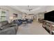 Spacious living room with tile floors, ceiling fan, and modern furnishings, open to the kitchen and dining area at 26950 Pavin Dr, Englewood, FL 34223