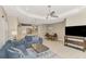 Bright living room featuring tile flooring, ceiling fan, and an open concept layout to the kitchen and dining area at 26950 Pavin Dr, Englewood, FL 34223