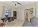 Home office featuring a ceiling fan, desk, and a comfortable gray sofa at 26950 Pavin Dr, Englewood, FL 34223