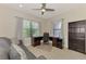 Comfortable office space featuring a ceiling fan, desk, bookcase, and a large window at 26950 Pavin Dr, Englewood, FL 34223