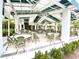 Outdoor dining area with ample seating, a covered patio, and lush landscaping at 26950 Pavin Dr, Englewood, FL 34223