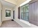 Covered front patio featuring neutral colors, brick flooring, and elegant windows with decorative shutters at 26950 Pavin Dr, Englewood, FL 34223