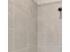 Close-up of the tiled shower with gray stone and a modern showerhead at 26950 Pavin Dr, Englewood, FL 34223
