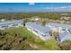 Complex of light blue buildings, green lawn, and distant landscape at 3923 Cape Haze Dr # 306, Rotonda West, FL 33947