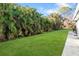 Spacious backyard with lush grass and tropical plants at 1115 Larchmont Dr, Englewood, FL 34223