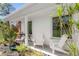 Inviting front porch with white chairs and a small table at 1115 Larchmont Dr, Englewood, FL 34223