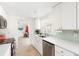 Bright kitchen with white cabinets, quartz countertops, and light green tile backsplash at 1115 Larchmont Dr, Englewood, FL 34223