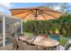 Outdoor patio with large wood table, umbrella, and seating at 1115 Larchmont Dr, Englewood, FL 34223