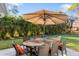 Outdoor patio with large wood table, umbrella, and seating at 1115 Larchmont Dr, Englewood, FL 34223