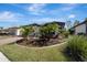 Landscaped yard with tropical plants surrounds a one-story house with gray siding at 1337 Sorrell Way, North Port, FL 34289