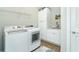 White laundry room with washer, dryer, and ample storage cabinets at 13092 Rinella St, Venice, FL 34293