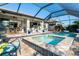 Enclosed pool and spa with covered patio, seating, and grill at 13092 Rinella St, Venice, FL 34293