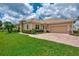 Tan house with tile roof, large driveway, and lush landscaping at 13104 Creekside Ln, Port Charlotte, FL 33953