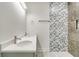 Double vanity bathroom with geometric tile shower at 384 Baytree Dr, Rotonda West, FL 33947