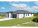 Gray house with dark gray roof and paver driveway at 384 Baytree Dr, Rotonda West, FL 33947