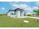 White house with gray roof, black garage door, and paved driveway at 384 Baytree Dr, Rotonda West, FL 33947