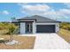 Single-story home with gray exterior and black garage door at 384 Baytree Dr, Rotonda West, FL 33947