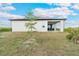 Rear view of house showcasing covered patio and yard at 384 Baytree Dr, Rotonda West, FL 33947