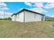 Side view of house showcasing gray exterior and yard at 384 Baytree Dr, Rotonda West, FL 33947