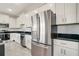 Modern kitchen with white cabinets, black countertops, and stainless steel appliances at 384 Baytree Dr, Rotonda West, FL 33947