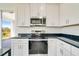 Modern kitchen with stainless steel appliances and dark countertops at 384 Baytree Dr, Rotonda West, FL 33947