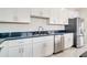 White shaker cabinets, stainless steel appliances and dark countertops at 384 Baytree Dr, Rotonda West, FL 33947