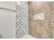 Shower with geometric patterned tile and built-in shelf at 384 Baytree Dr, Rotonda West, FL 33947