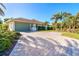 Paved driveway leading to a two-car garage, surrounded by beautiful landscaping and green spaces at 65 Par View Ter, Rotonda West, FL 33947