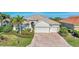 Tan two-story house with tile roof, large driveway, and lush landscaping at 13025 Cedar Creek Dr, Port Charlotte, FL 33953