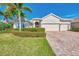 Well-maintained house with a three-car garage, palm trees, and manicured lawn at 13025 Cedar Creek Dr, Port Charlotte, FL 33953