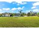 Landscaped backyard with canal views, boat dock, and outdoor kitchen at 15576 Aldama Cir, Port Charlotte, FL 33981