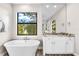 Elegant bathroom with soaking tub, white vanity, and marble countertops at 15576 Aldama Cir, Port Charlotte, FL 33981