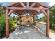 Rustic outdoor kitchen with grill and bar under a pergola at 15576 Aldama Cir, Port Charlotte, FL 33981