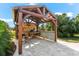 Rustic outdoor kitchen with grill and bar under a pergola at 15576 Aldama Cir, Port Charlotte, FL 33981