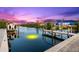 Stunning waterfront view at sunset featuring a private dock and boat lift at 15576 Aldama Cir, Port Charlotte, FL 33981