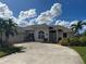 House exterior showcasing a well-maintained front yard and driveway at 93 Fairway Rd, Rotonda West, FL 33947