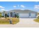 House exterior featuring a three-car garage and landscaped yard at 13838 Begonia Cir, Port Charlotte, FL 33981