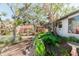 Landscaped backyard with a brick pathway and lush greenery at 700 Coquina Ct, Nokomis, FL 34275