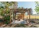 Relaxing pergola with fire pit and seating area in the backyard at 700 Coquina Ct, Nokomis, FL 34275