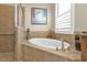 Relaxing bathroom with soaking tub and large window at 13215 Amerigo Ln, Venice, FL 34293