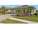 Beautiful house exterior with three-car garage and lush landscaping at 13215 Amerigo Ln, Venice, FL 34293