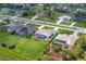 Aerial view of a home with screened lanai, well-manicured lawn, and mature trees at 180 Rotonda N Blvd, Rotonda West, FL 33947